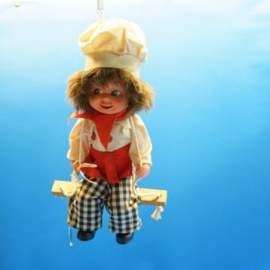 60er Jahre Bäckerei Schaufensterfigur hängend auf einer Schaukel